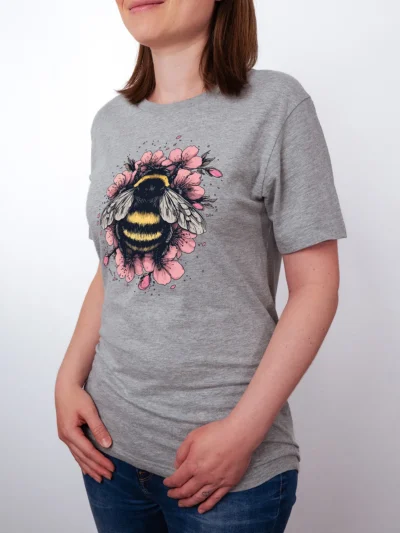 Sakura Hummel T-Shirt in Athletic Heather, getragen von einem Damen Model, in der Ansicht von seite.